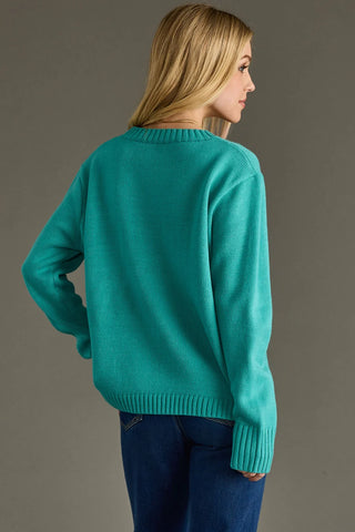 Person wearing a teal sweater on a gray background